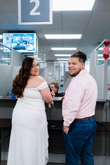 A couple shares a romantic moment while waiting in line at a DMV office.