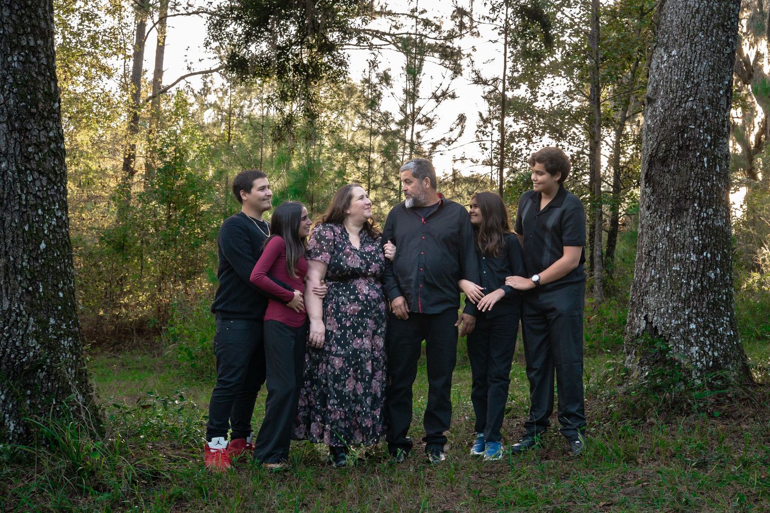 Group photo of family members gathered together in a wooded outdoor setting.