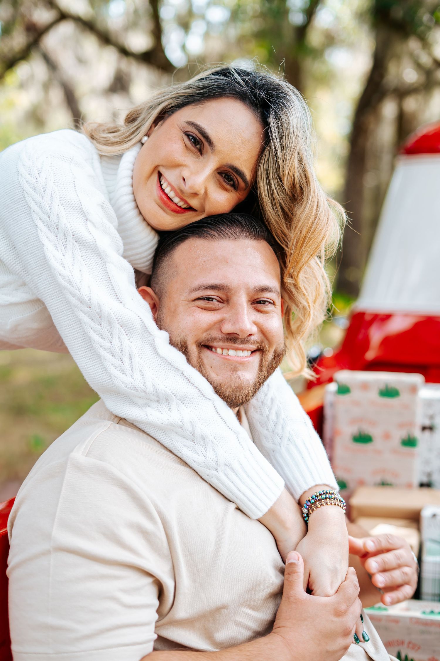A couple embraces while sitting together in casual attire.