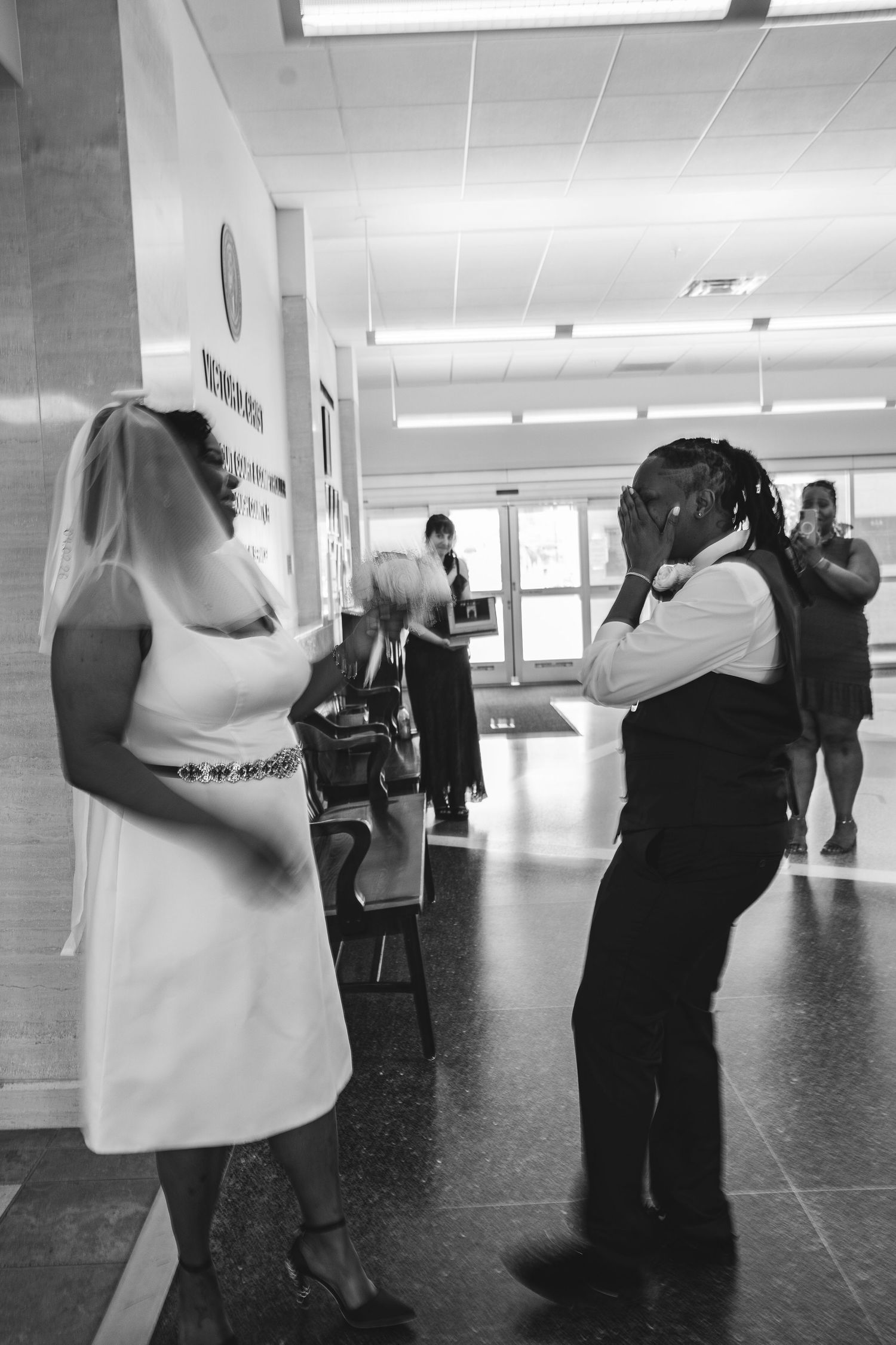 Black and white photo of a bride and groom sharing an emotional moment at a courthouse wedding ceremony.