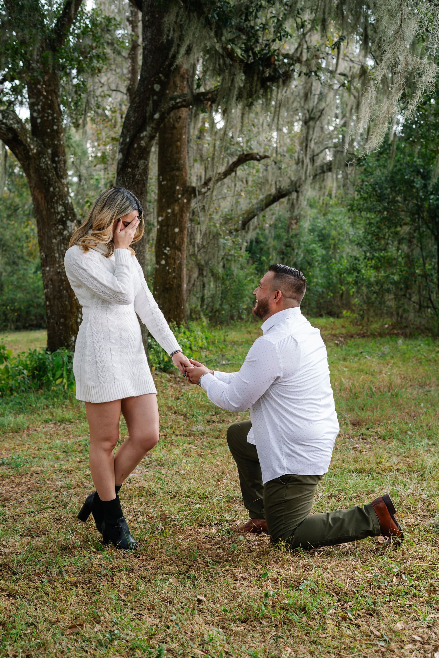 A romantic outdoor photoshoot in a mossy woodland setting with Spanish moss hanging from trees.