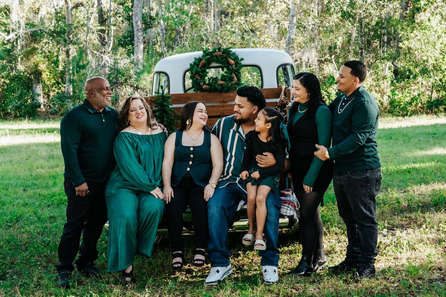 Group photo of people in coordinated green and black outfits posed by a vintage truck.