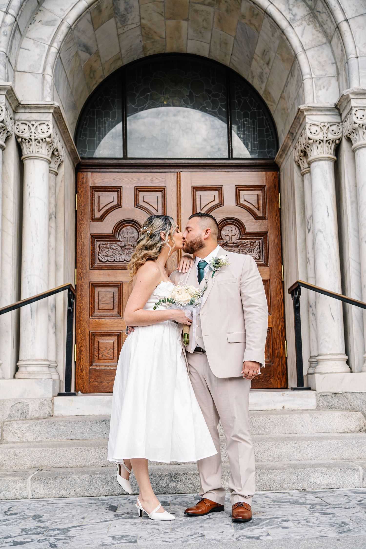 Four romantic moments captured in sequence showing a couple in formal attire embracing under ornate stone archways.