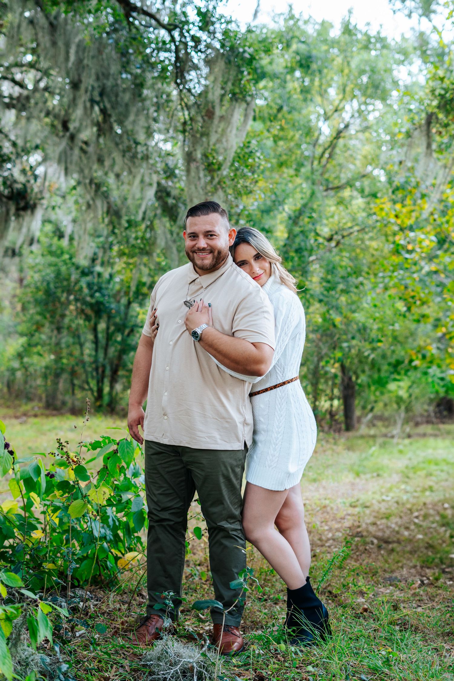 A couple shares tender moments together in a lush green garden setting during a photo session.