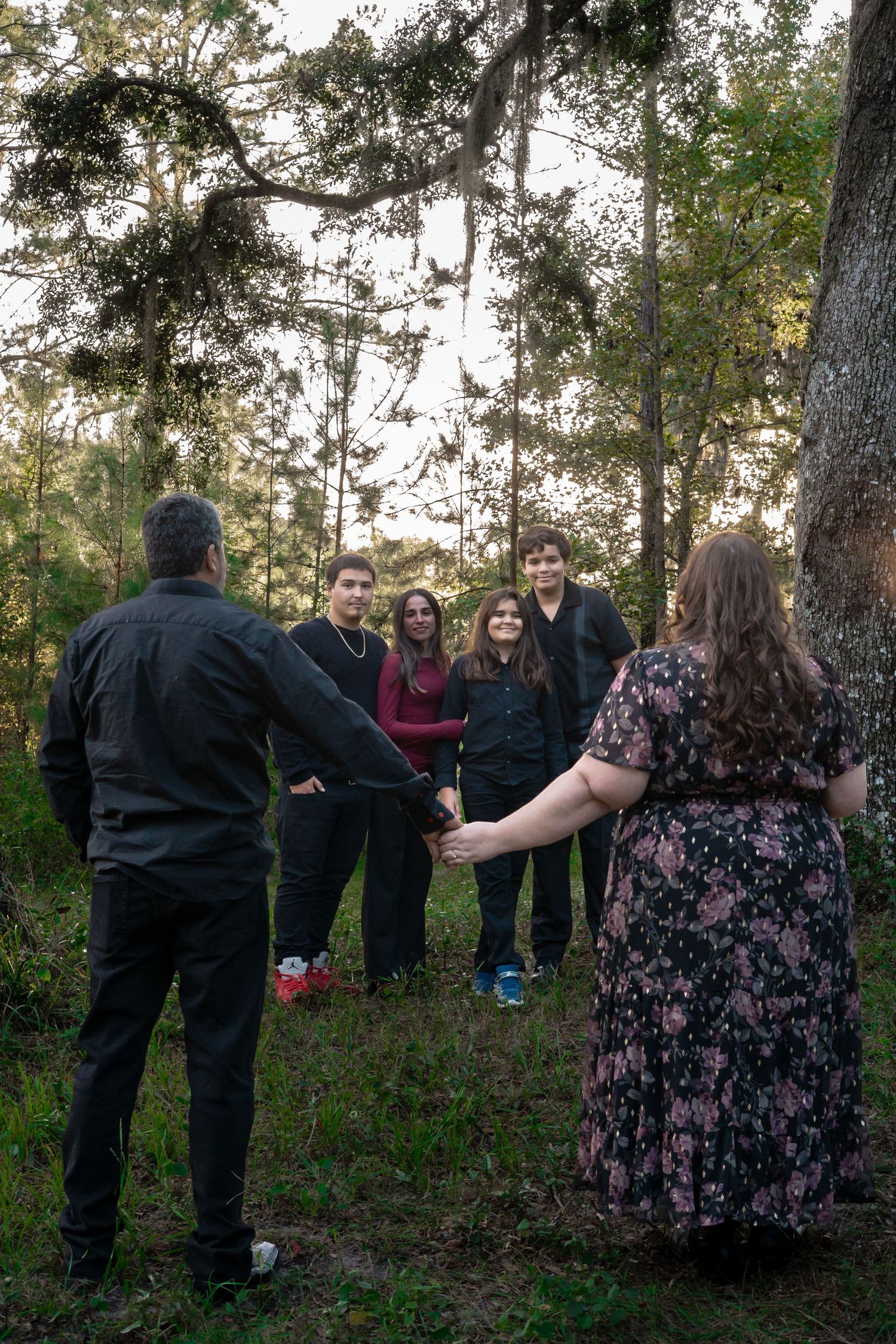 Group of people in casual attire gathered in a circle formation outdoors.