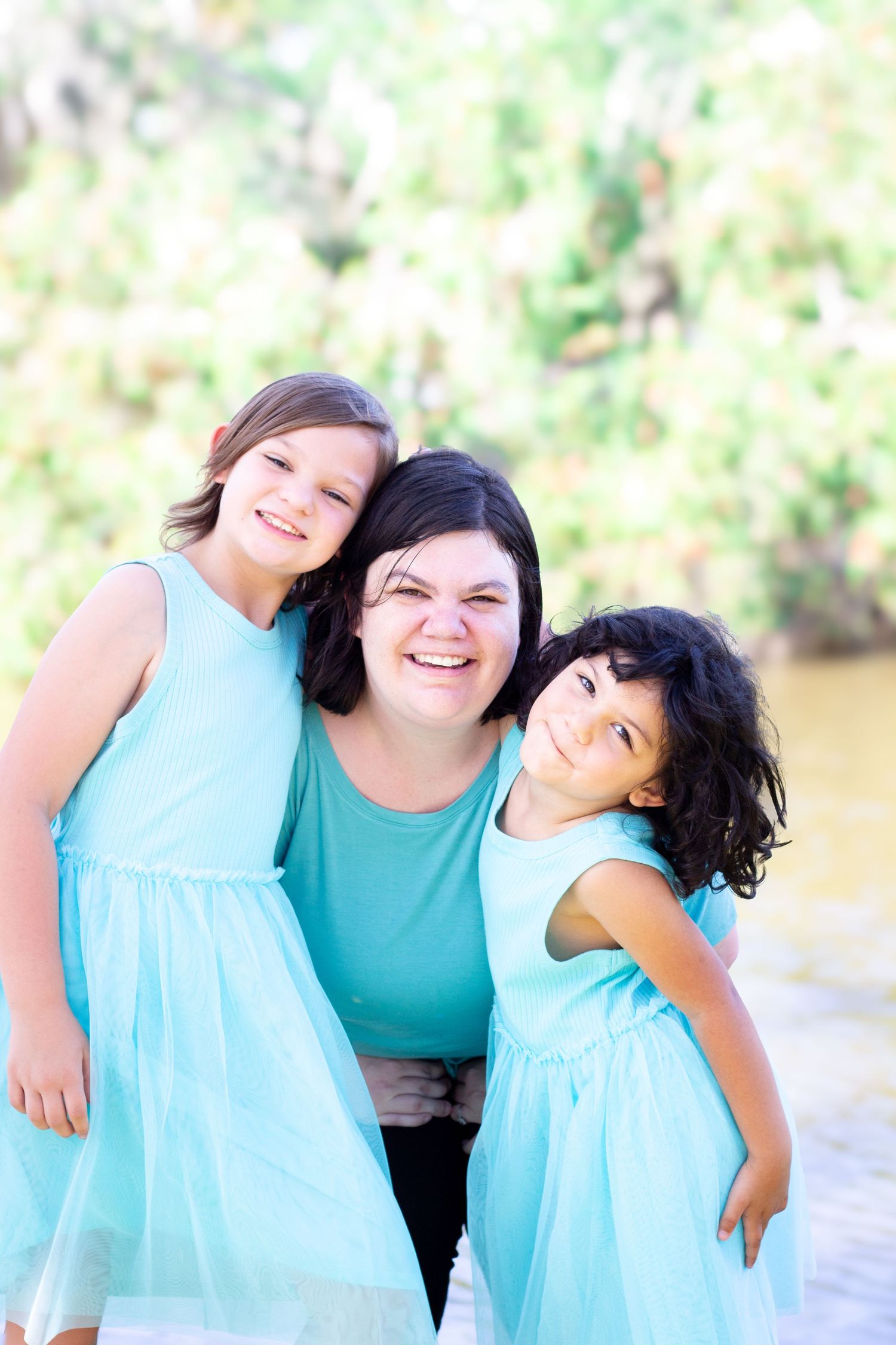 Sweet family moment captured in matching turquoise outfits outdoors.