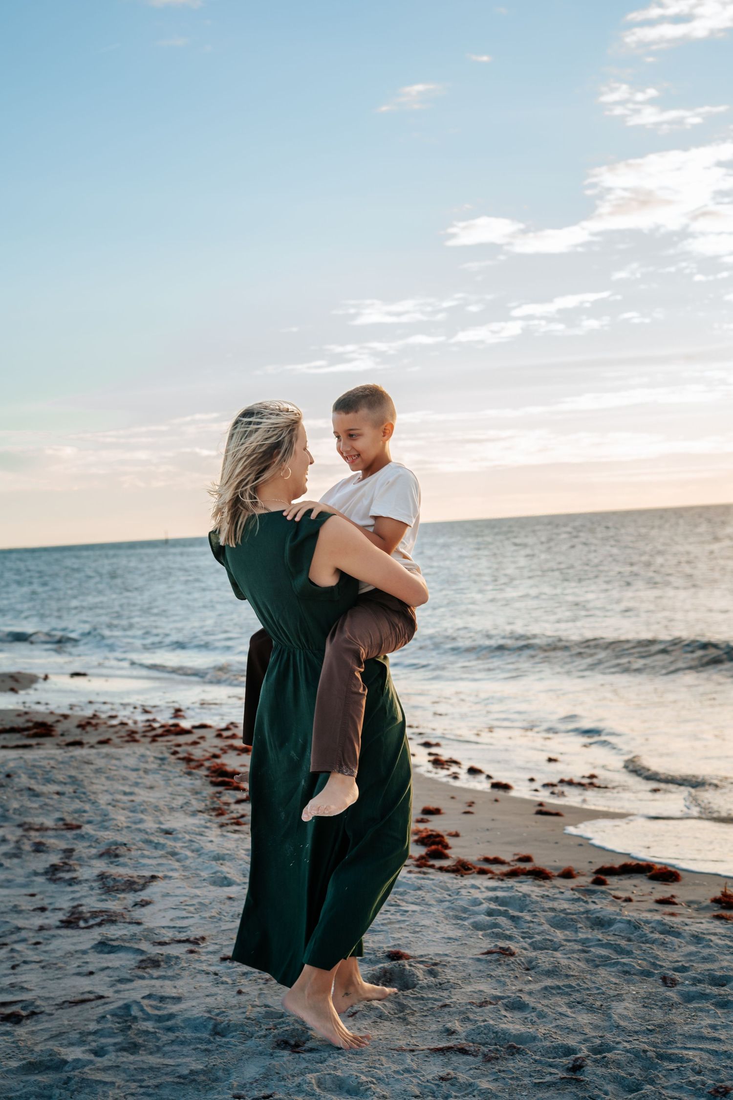 A joyful moment shared between loved ones on a scenic beach at sunset.