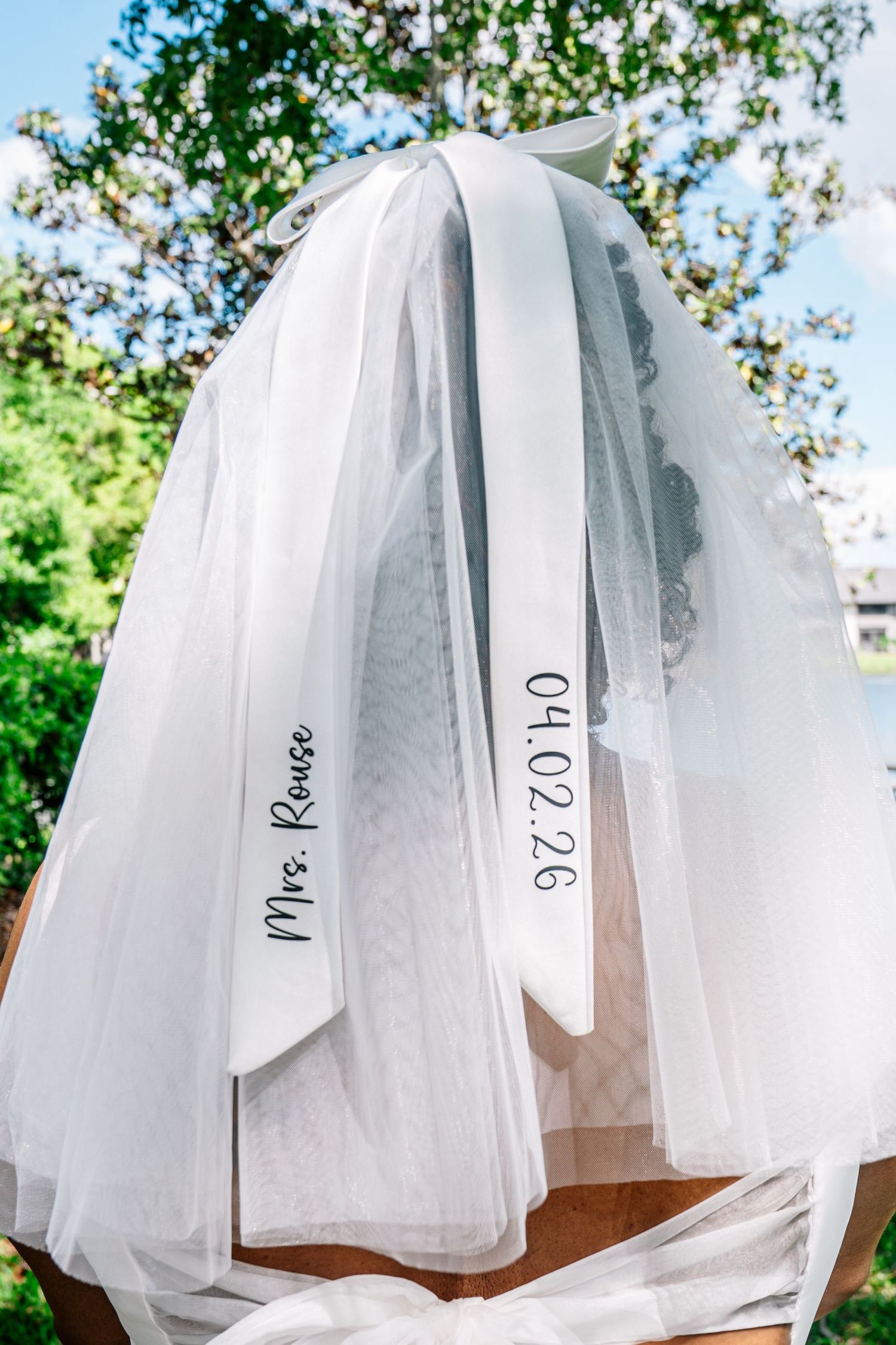 Personalized wedding veil with Mrs. Rouse and date 04.02.26 embroidered on white ribbon trim.