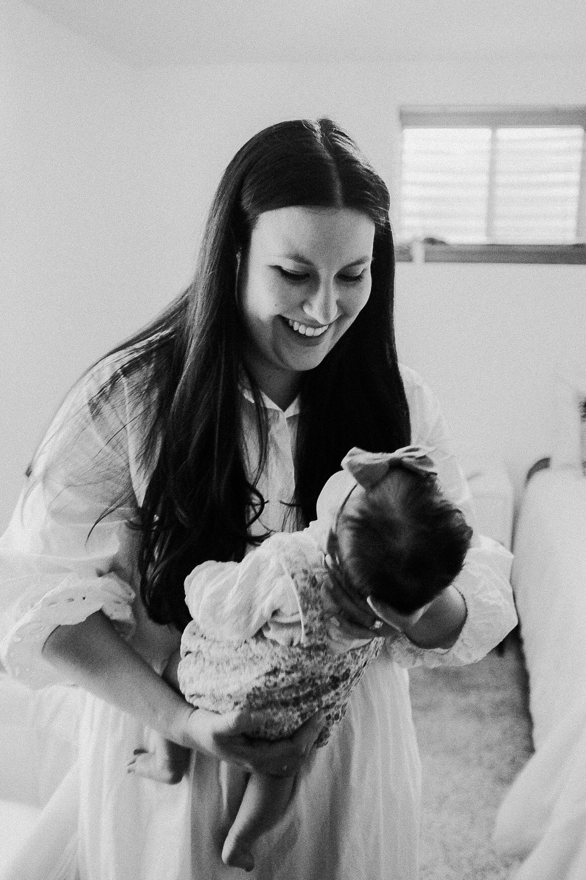 A joyful black and white portrait in an airy, light-filled room.