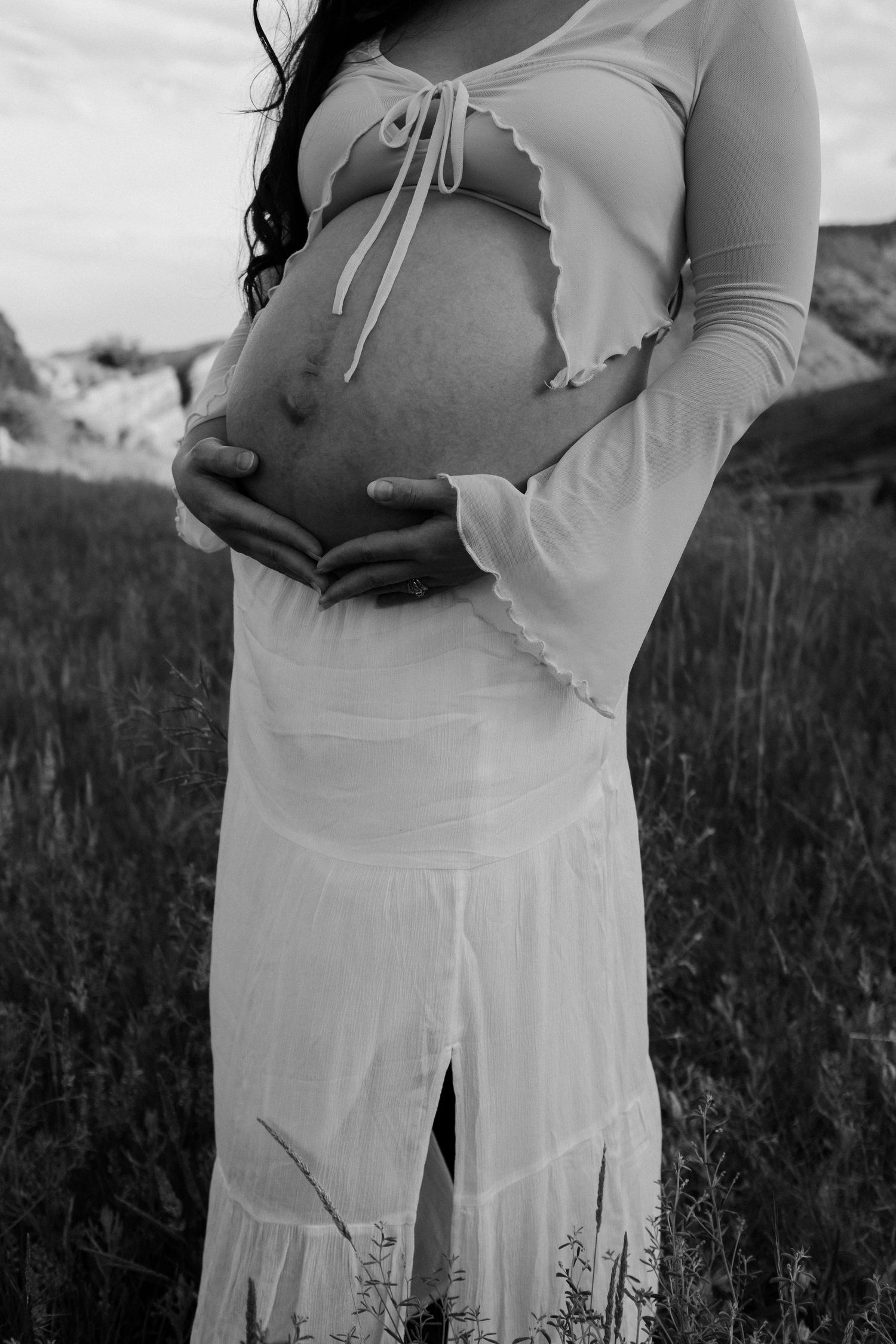 Black and white maternity photo showing intimate moment in nature.