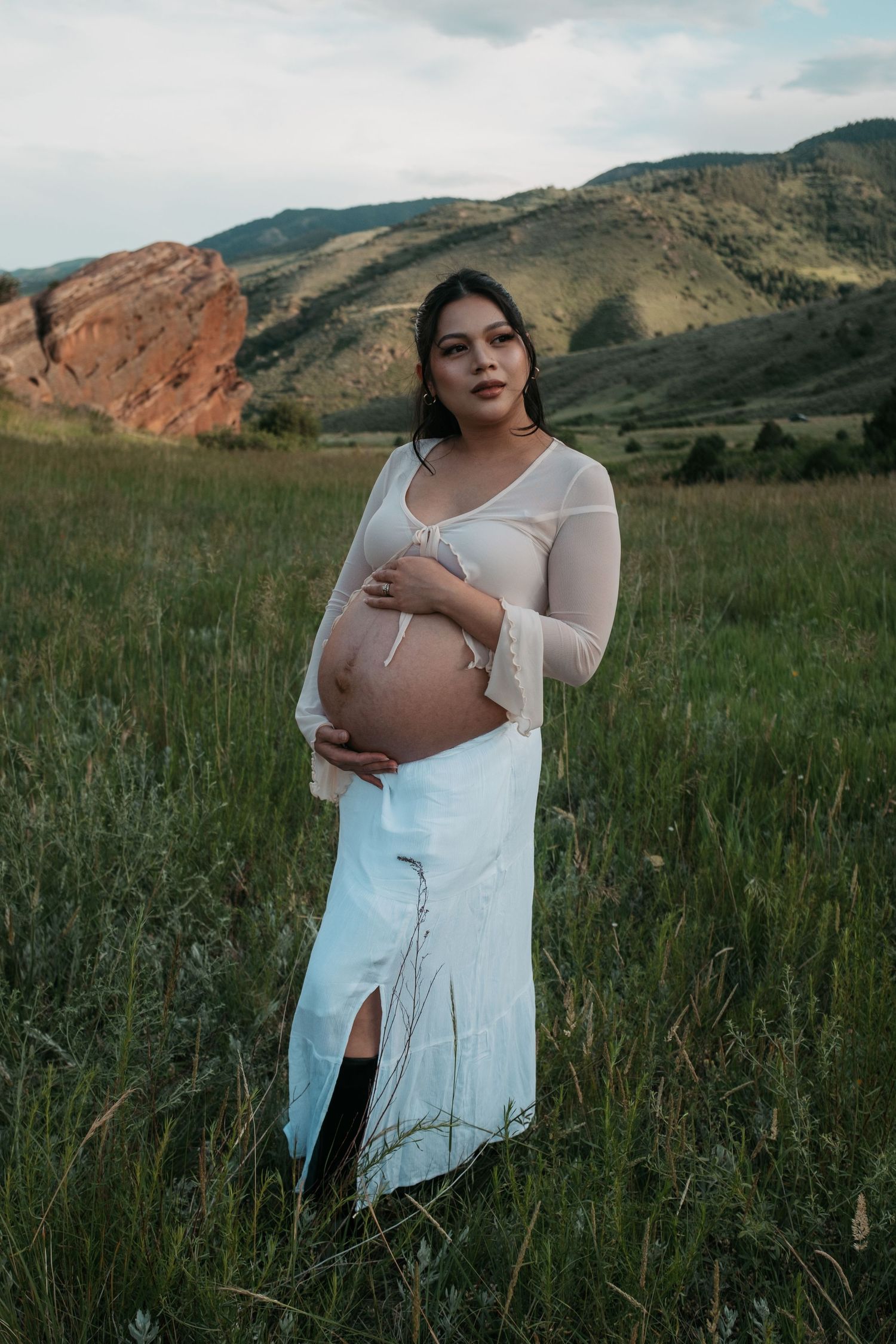 Peaceful maternity moment captured against mountainous terrain and red rocks.