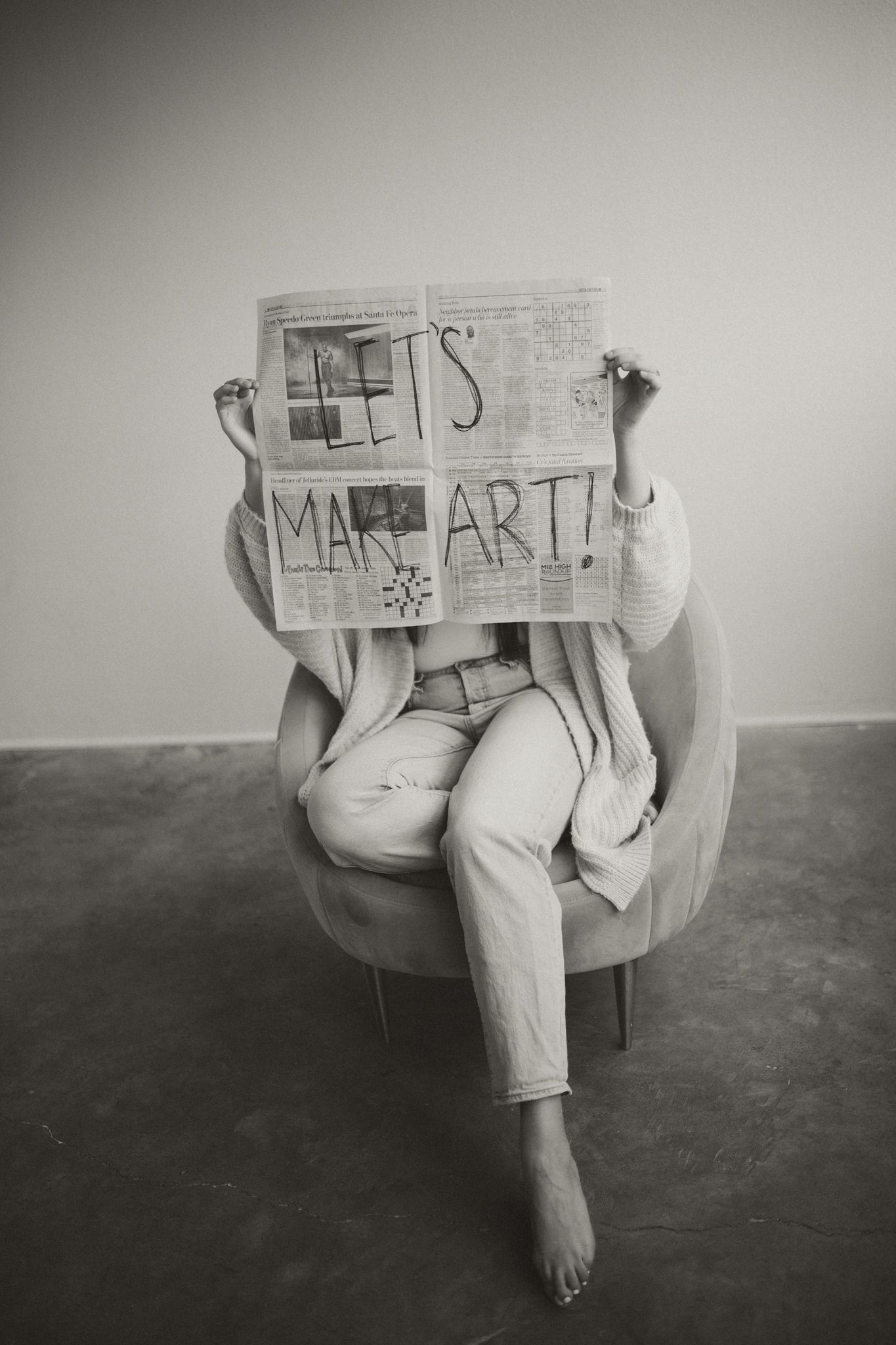 A black and white photograph series shows someone sitting with handmade cardboard signs displaying various messages.