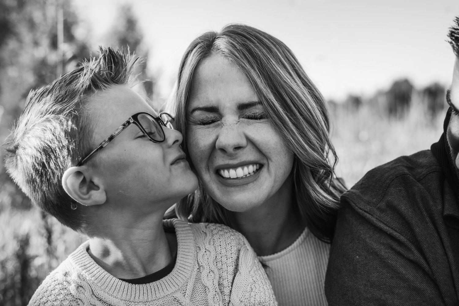 A joyful black and white candid moment captured outdoors on a sunny day.