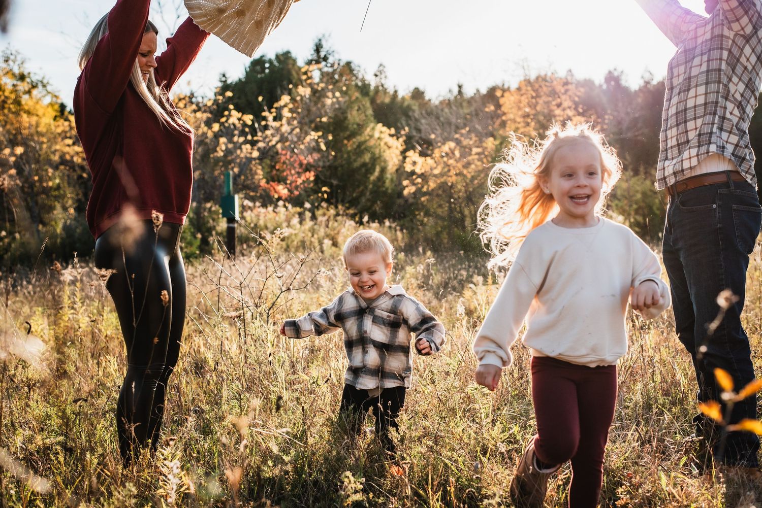 A heartwarming autumn photoshoot in a golden field during sunset with loved ones enjoying quality time together.