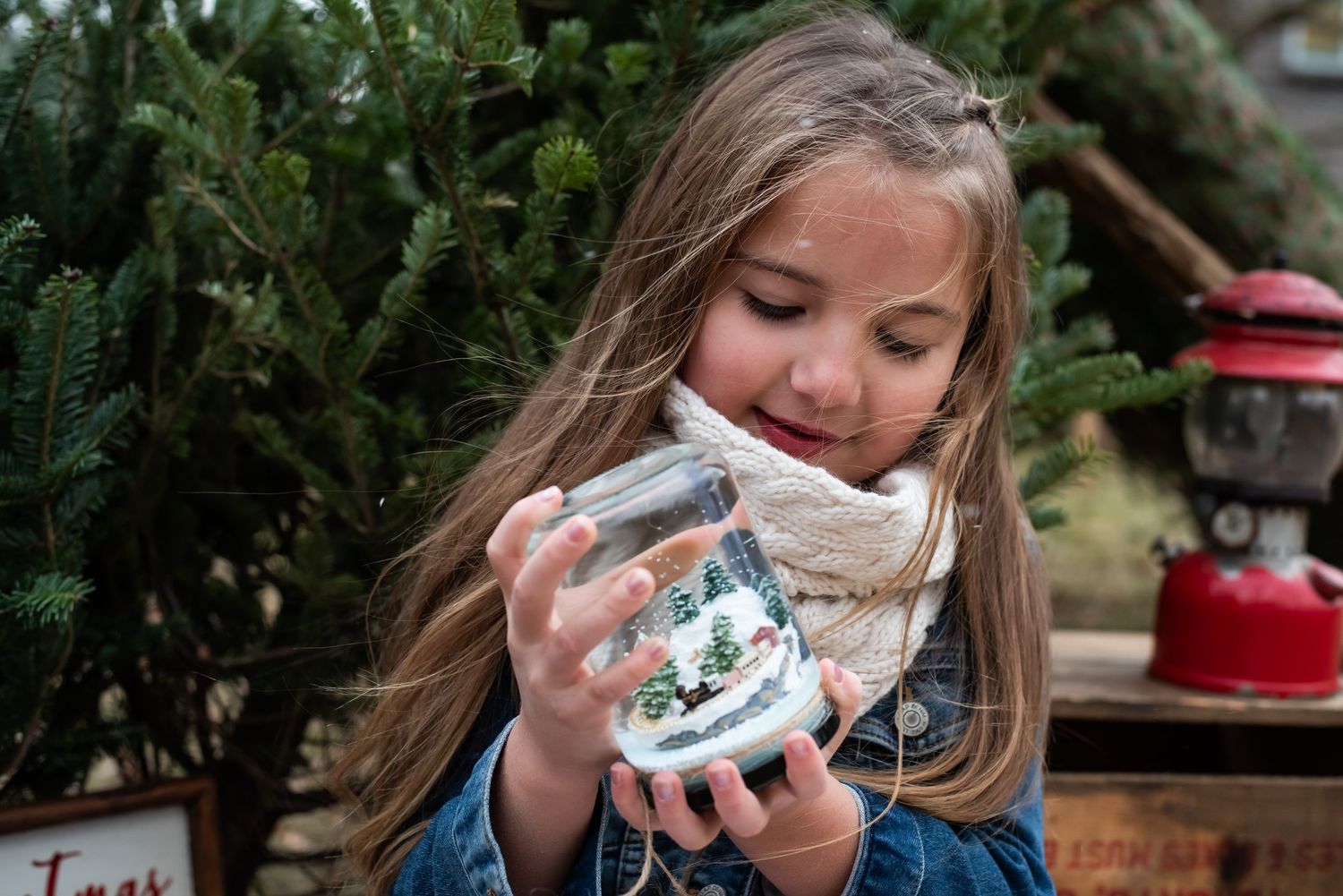 A person sips from a delicate teacup while seated outdoors near greenery and garden decorations.