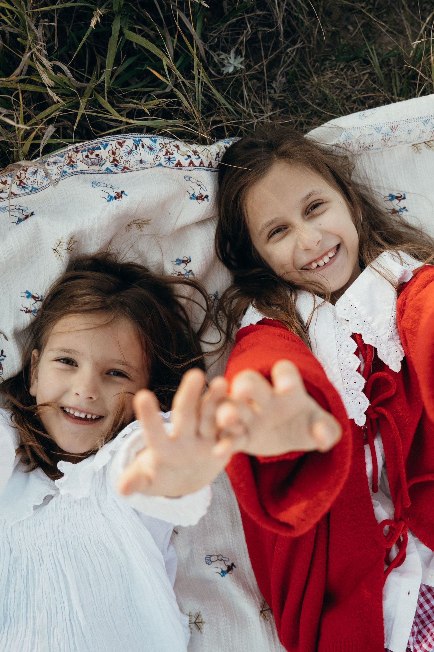 A sequence of playful moments on a white pillow showing someone in a bright red sweater.