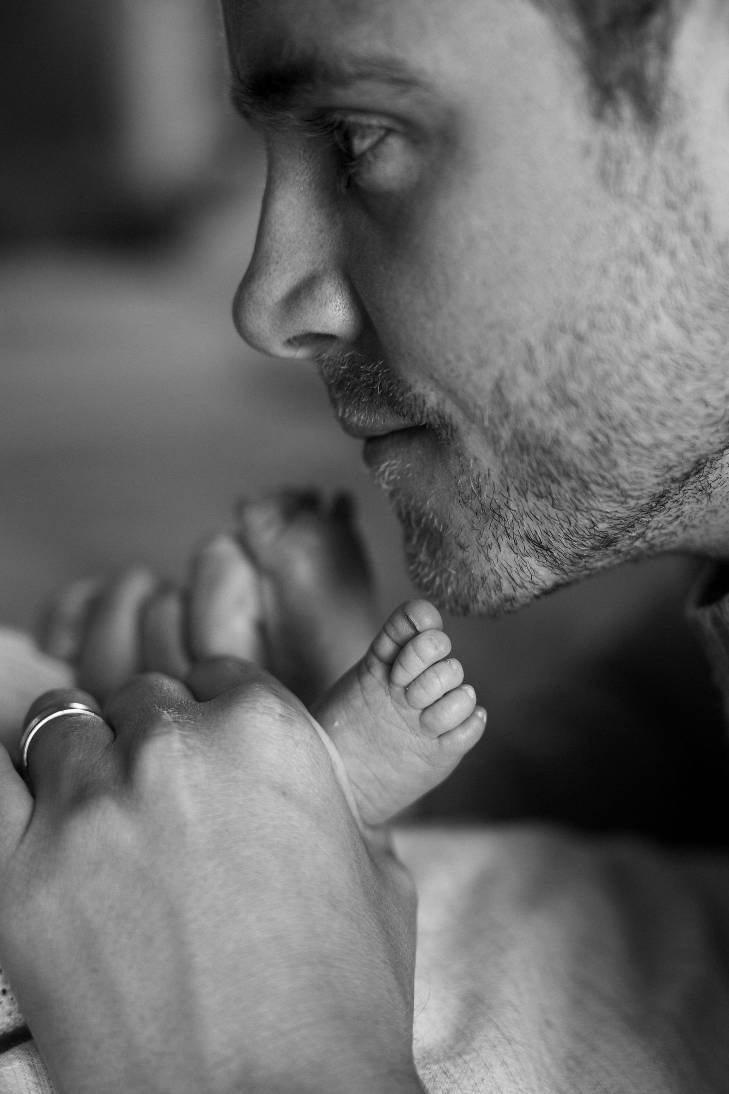 A close-up black and white photo of a person touching their chin thoughtfully in a contemplative pose.