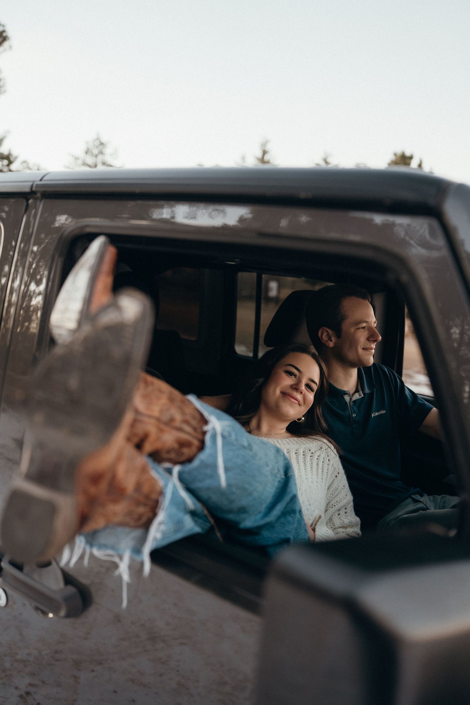 A couple shares a cozy moment inside a vehicle on a winter day.
