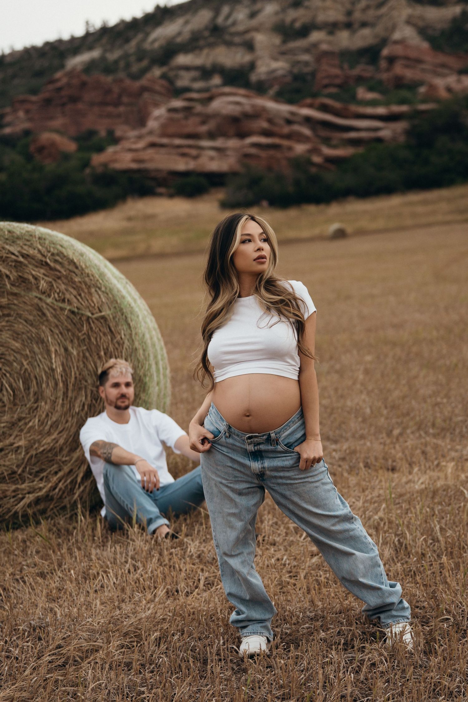 Family portrait session with vintage style hale bales and red rock formations in the background on a fall day.