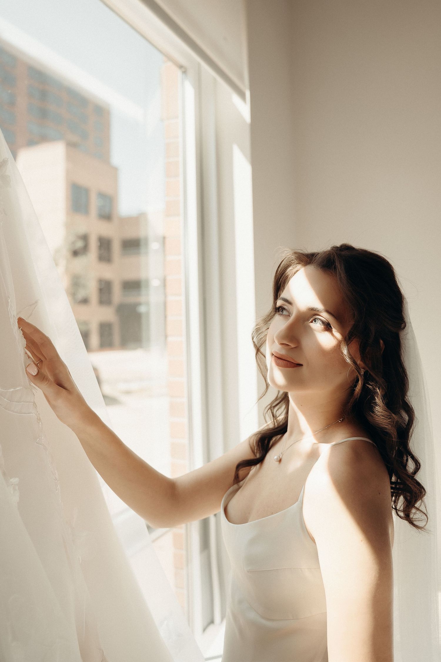 Soft morning light streams through white curtains creating a dreamy atmosphere in an interior setting.