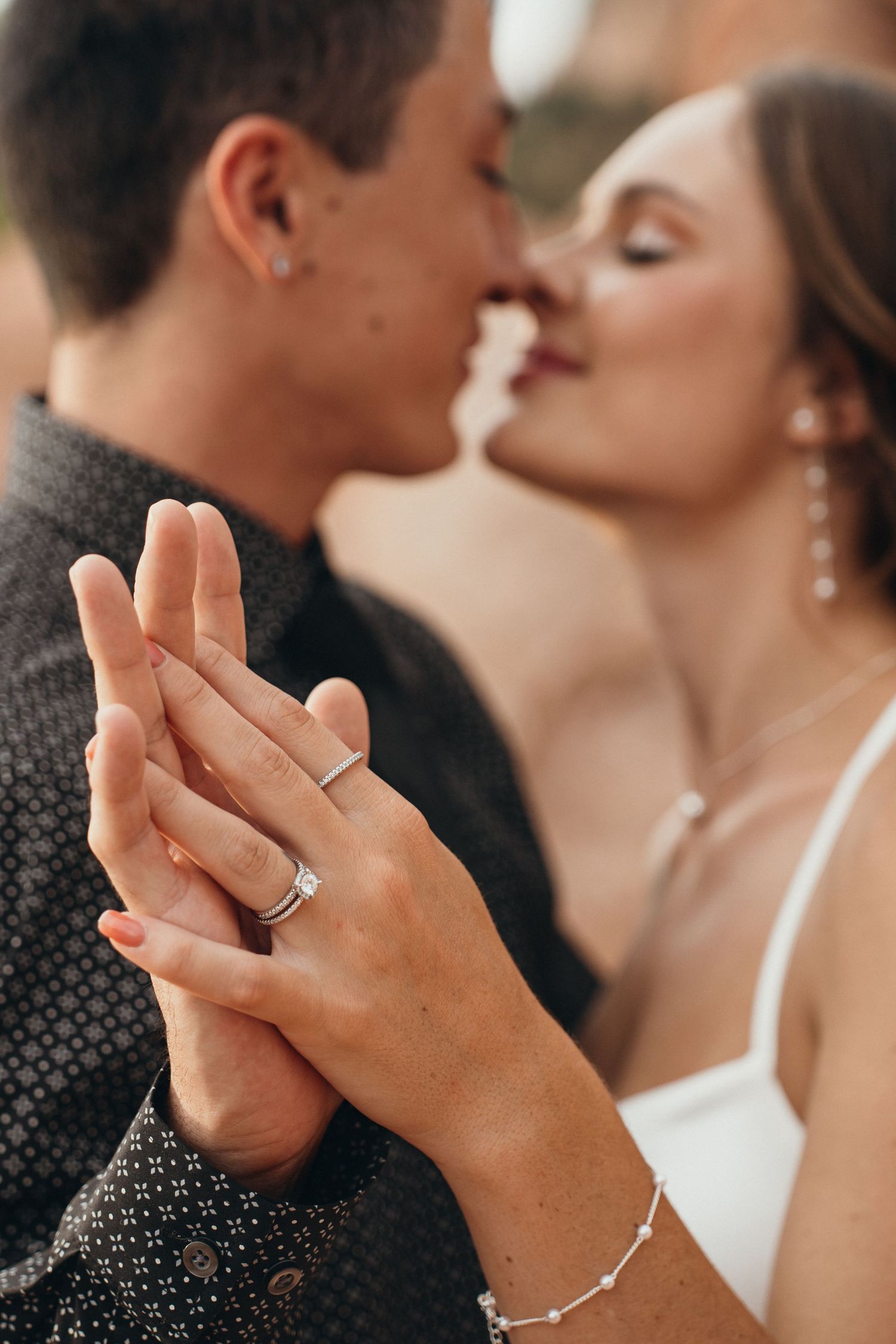 Close up shot of hands with wedding rings as a couple shares an intimate moment.