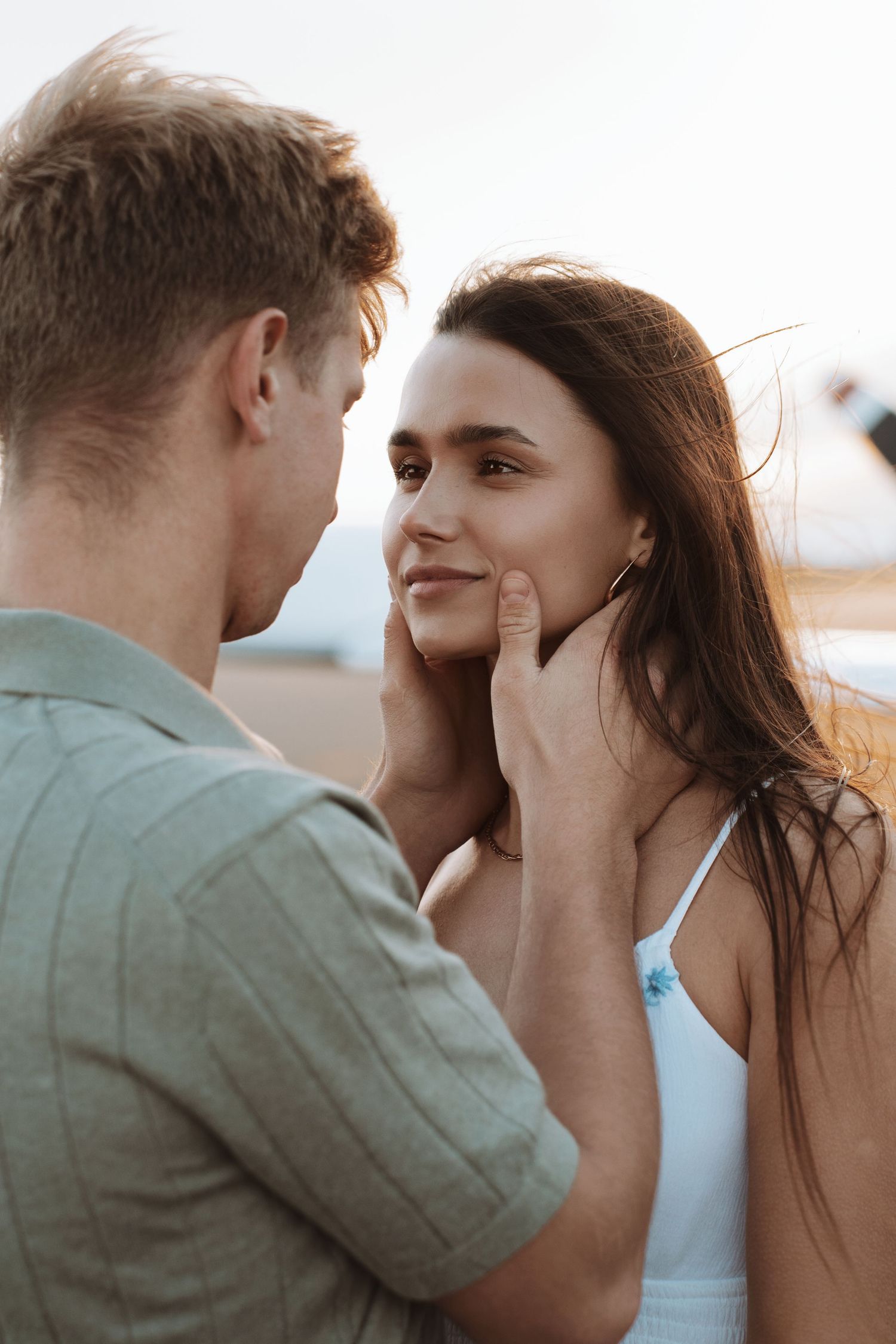 A tender romantic moment between a couple as they share an intimate gaze at sunset.