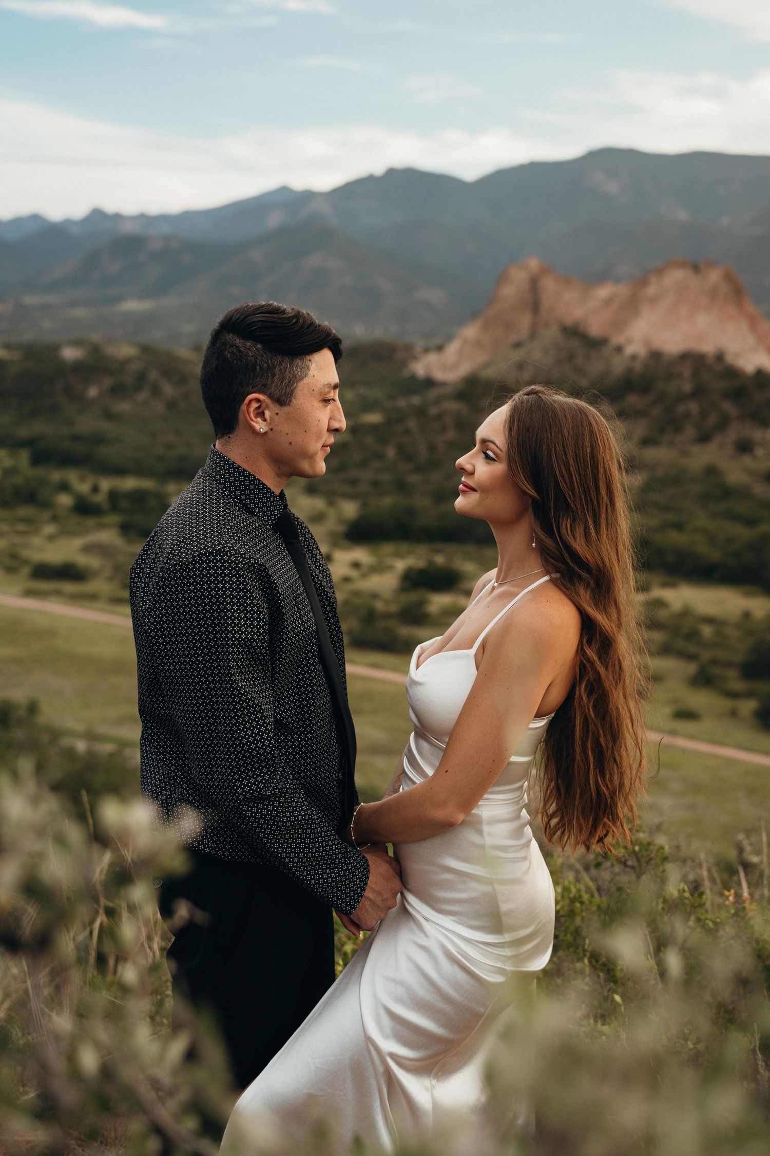 Intimate couple photography session in front of scenic mountain landscape at golden hour.