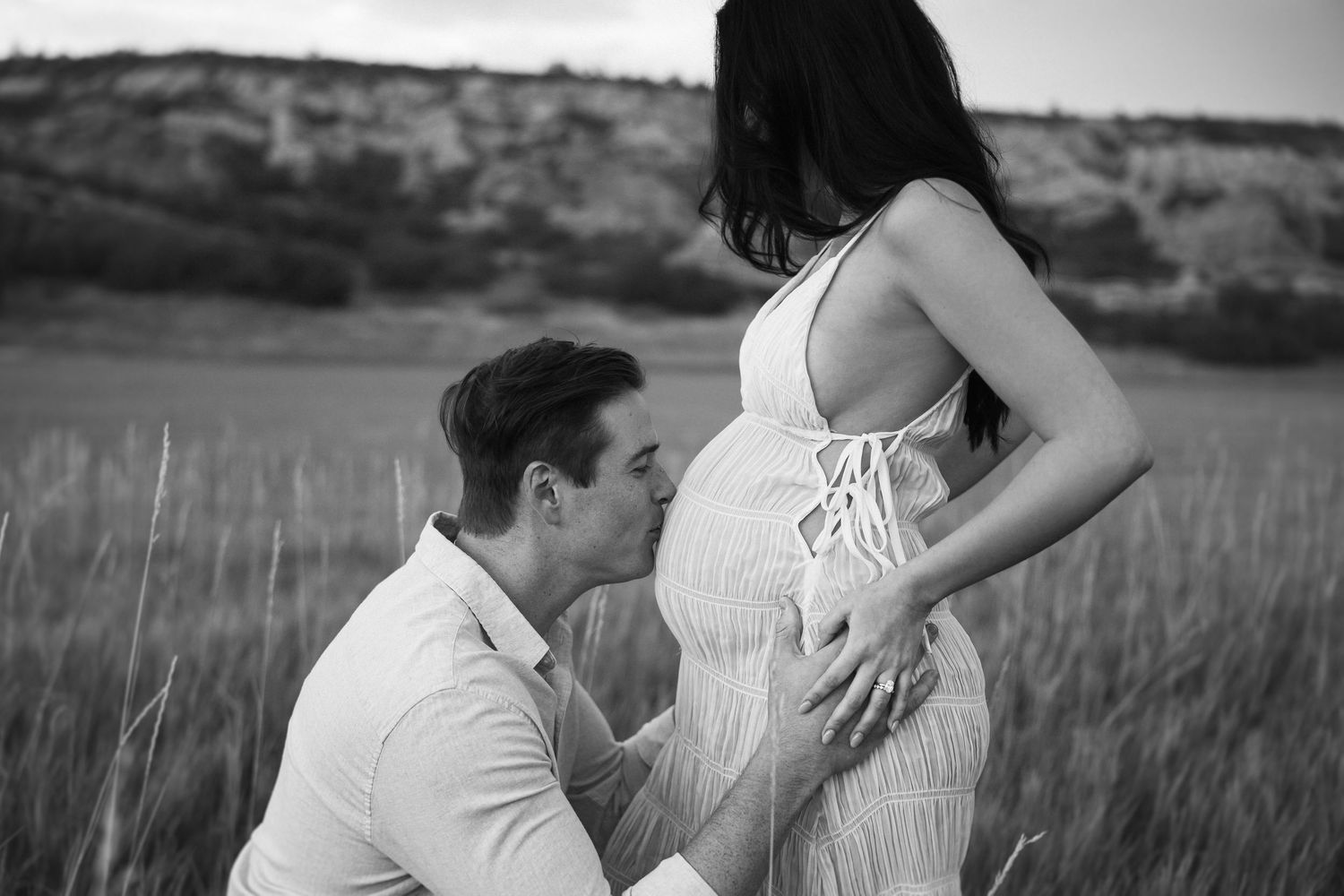 A romantic black and white photo sequence shows a tender moment between a couple in a grassy field.