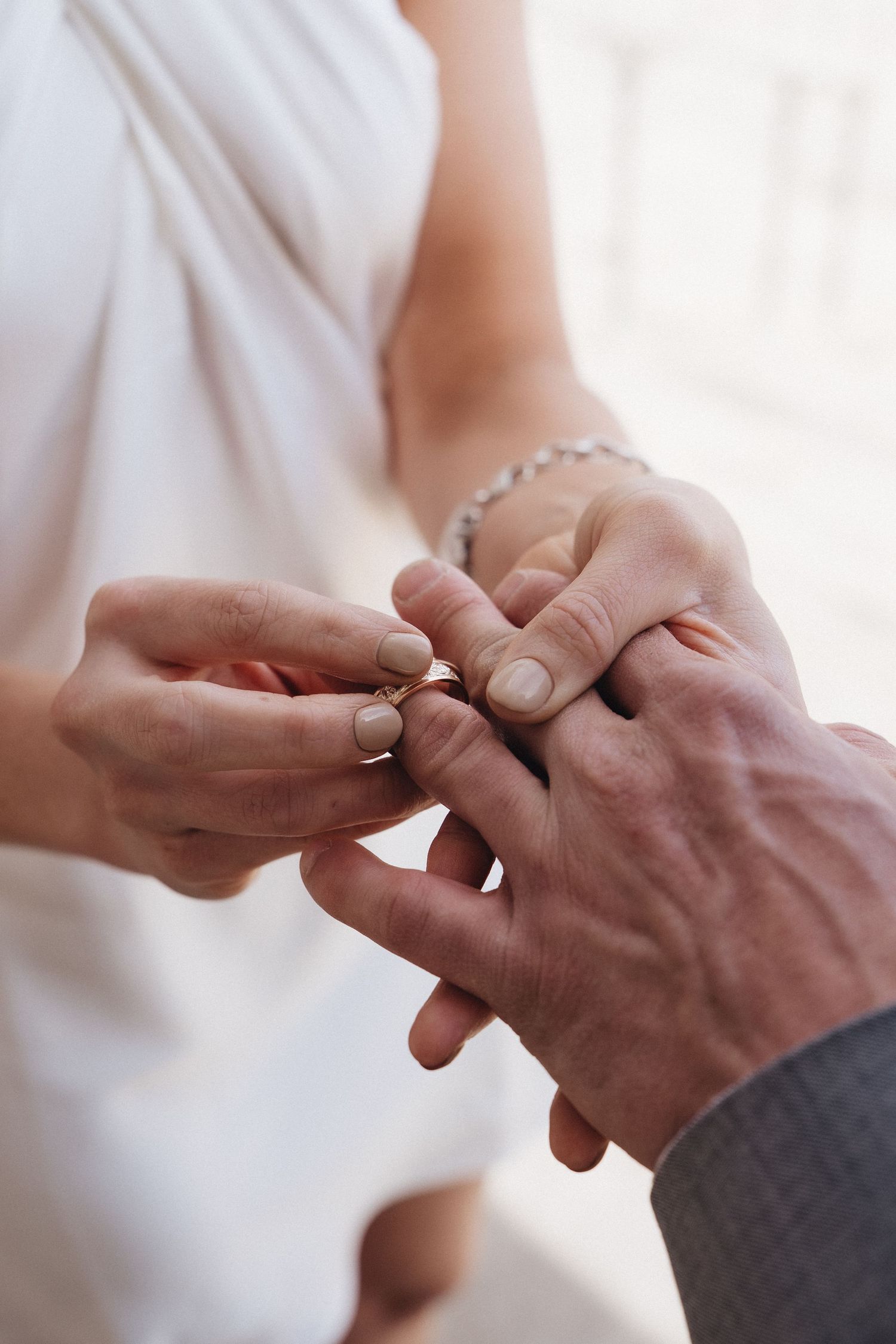 Close-up sequence showing hands exchanging wedding rings during a romantic ceremony.