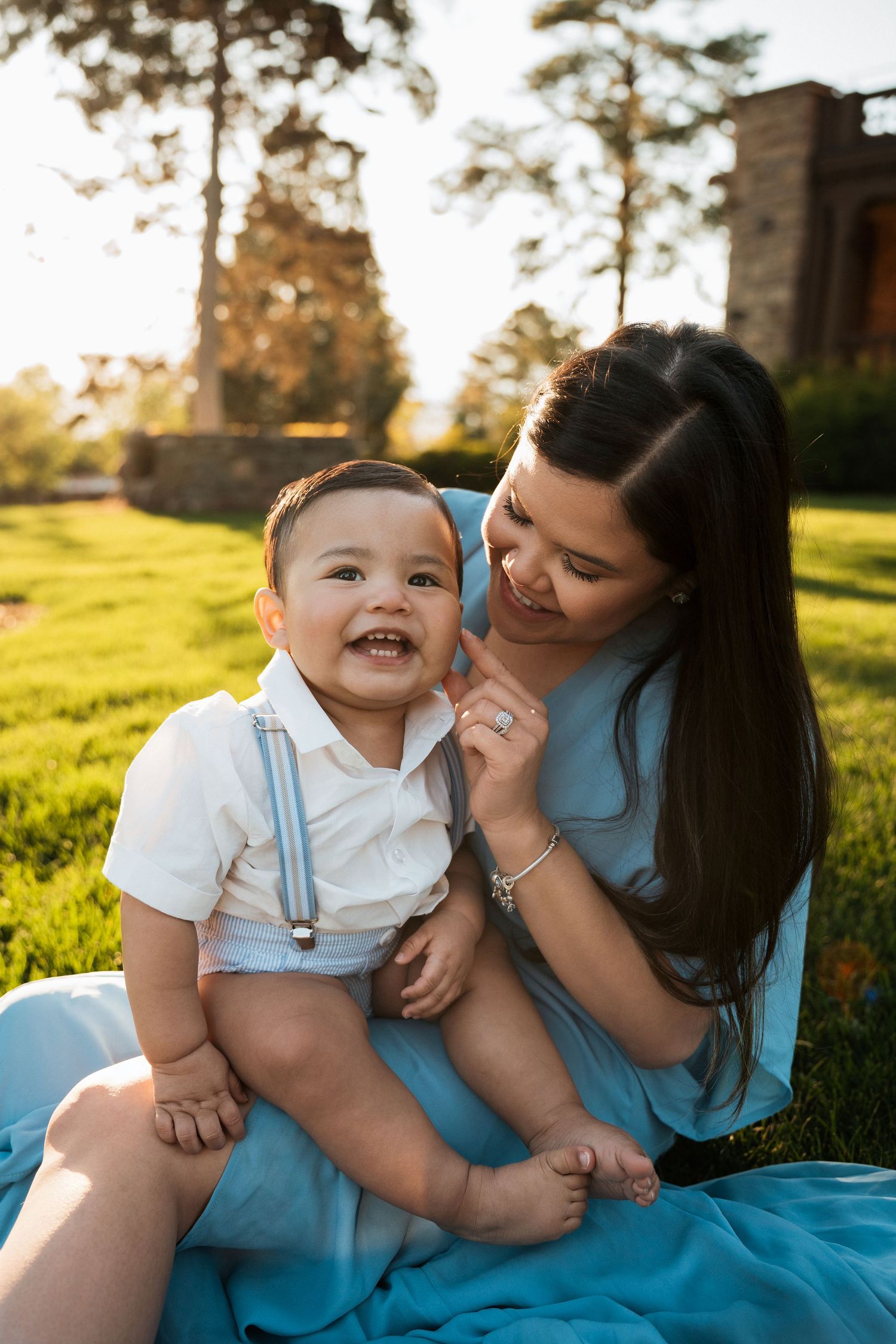 Carefree outdoor moment shared in a grassy field at sunset with blue outfits and joyful laughter.