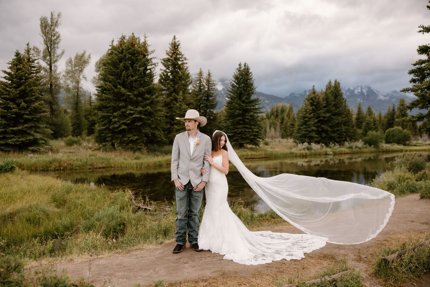 Bride and groom portrait at Grand Teton National Park with dramatic mountain backdrop and flowing veil.