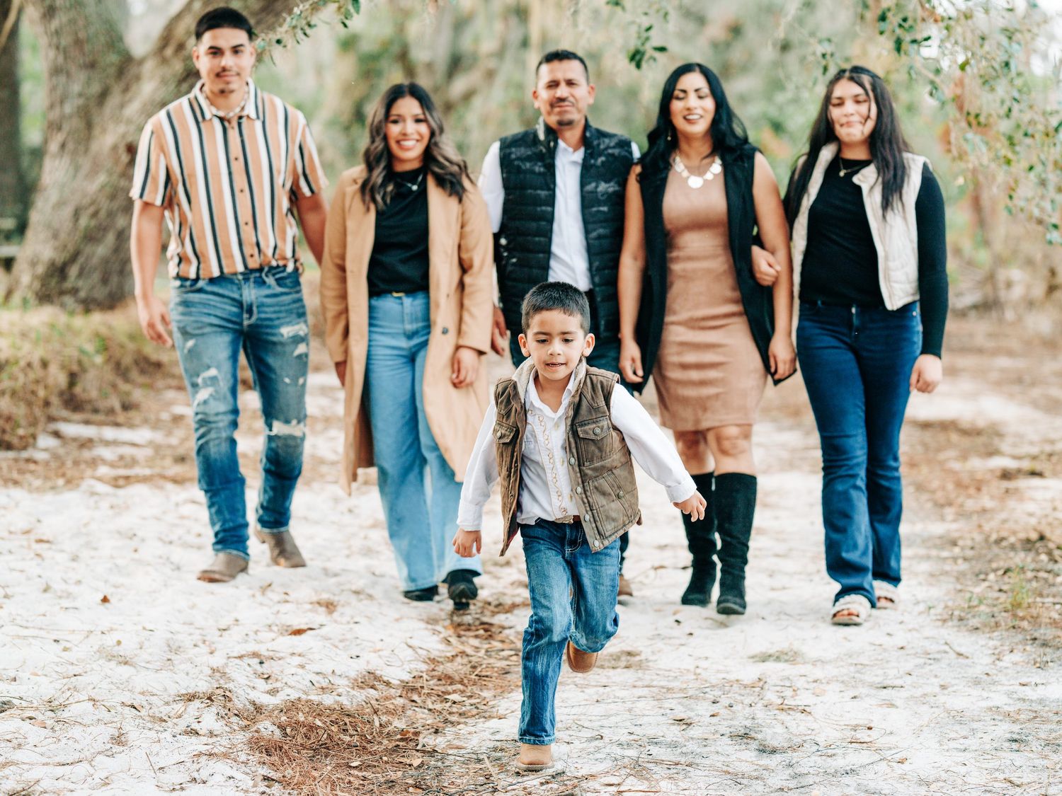 Young boy running ahead of his family on a sandy trail at Lake Louisa State Park, Clermont, Florida family photos