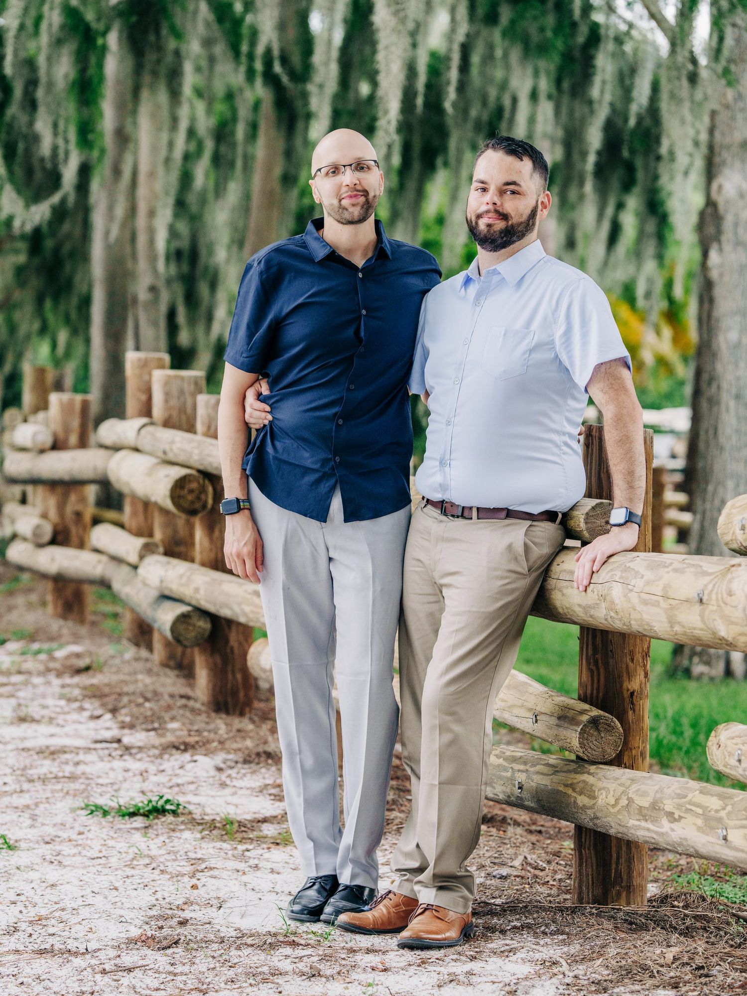 Couple by a rustic wooden fence under Spanish moss at Disney's Wilderness Lodge, Orlando surprise proposal photography