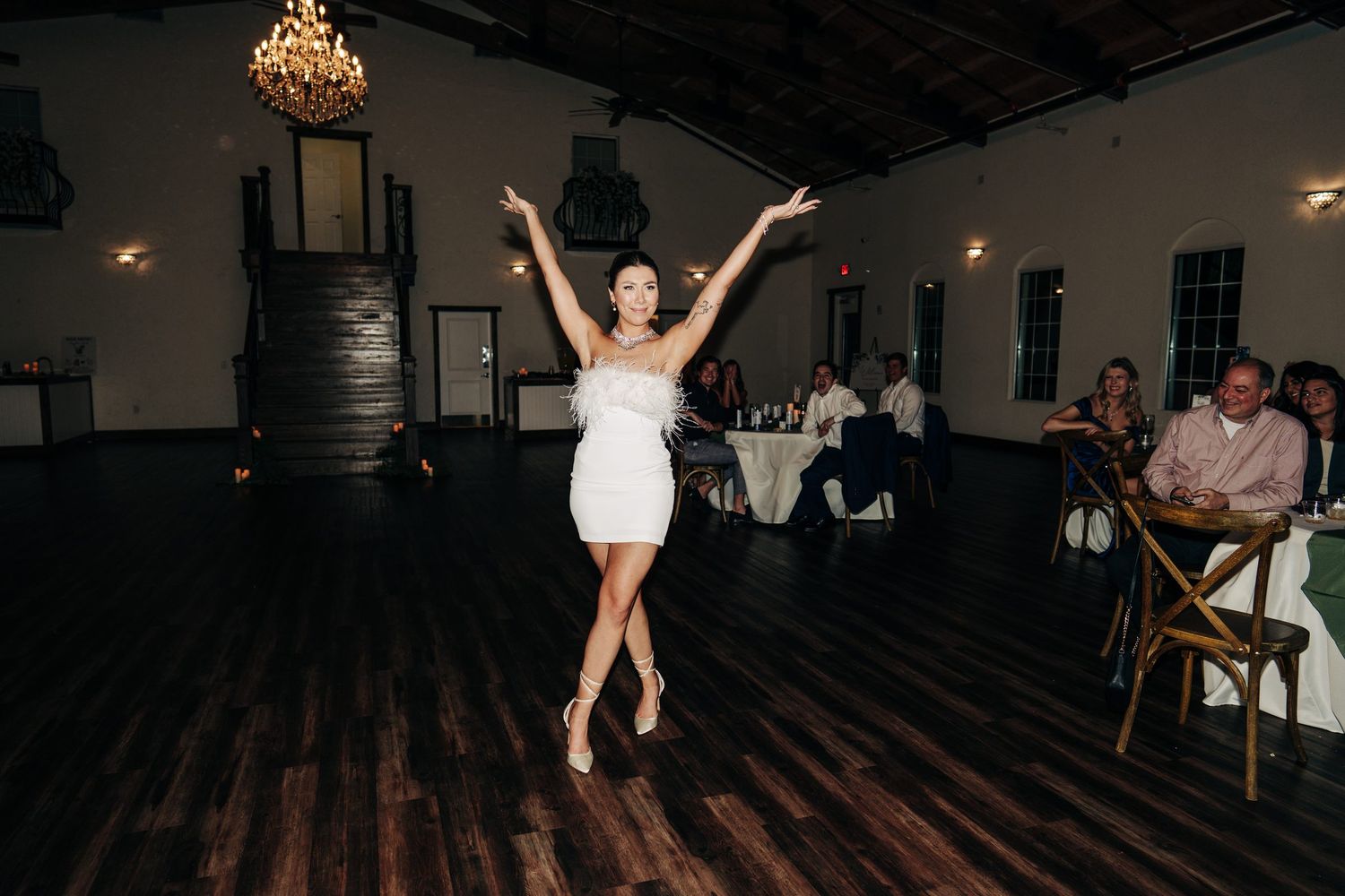 Guest in a white dress twirling on the dance floor at Sterling Event Venue in Minneola, Florida wedding reception