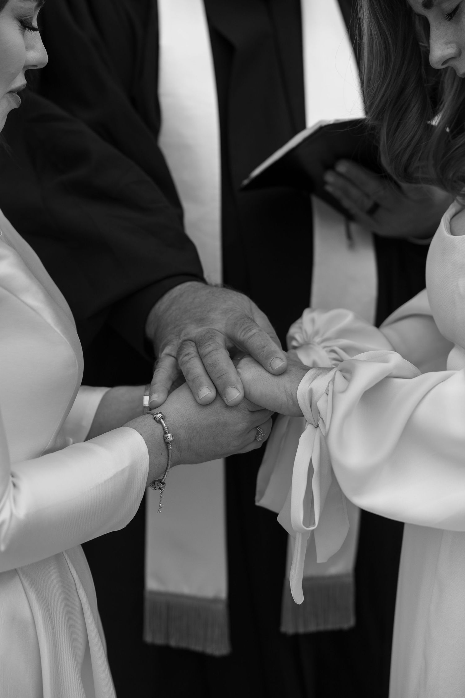 Close-up sequence of hands adjusting white formal dress sleeves in black and white photography.