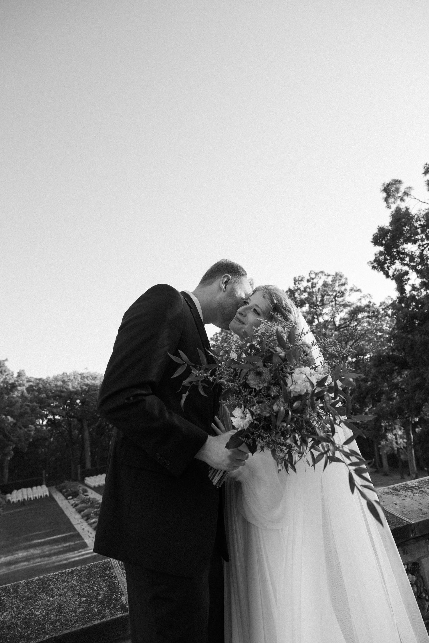 Wedding couple embraces during intimate outdoor photo session at dusk.
