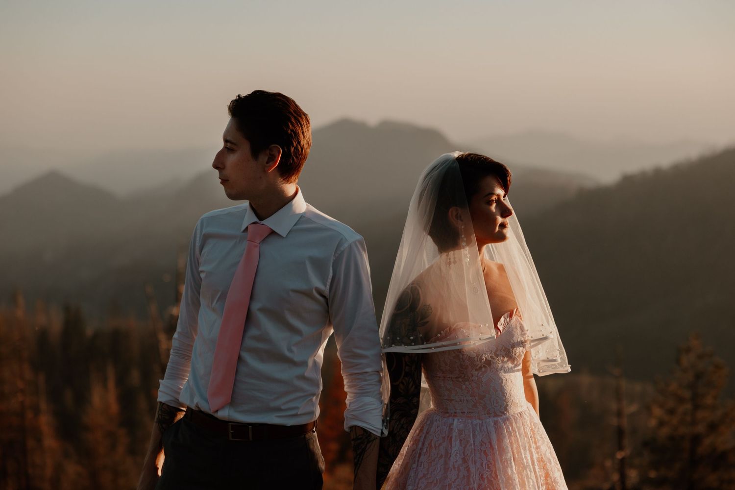Sunset silhouettes of couple against mountains create romantic atmosphere.
