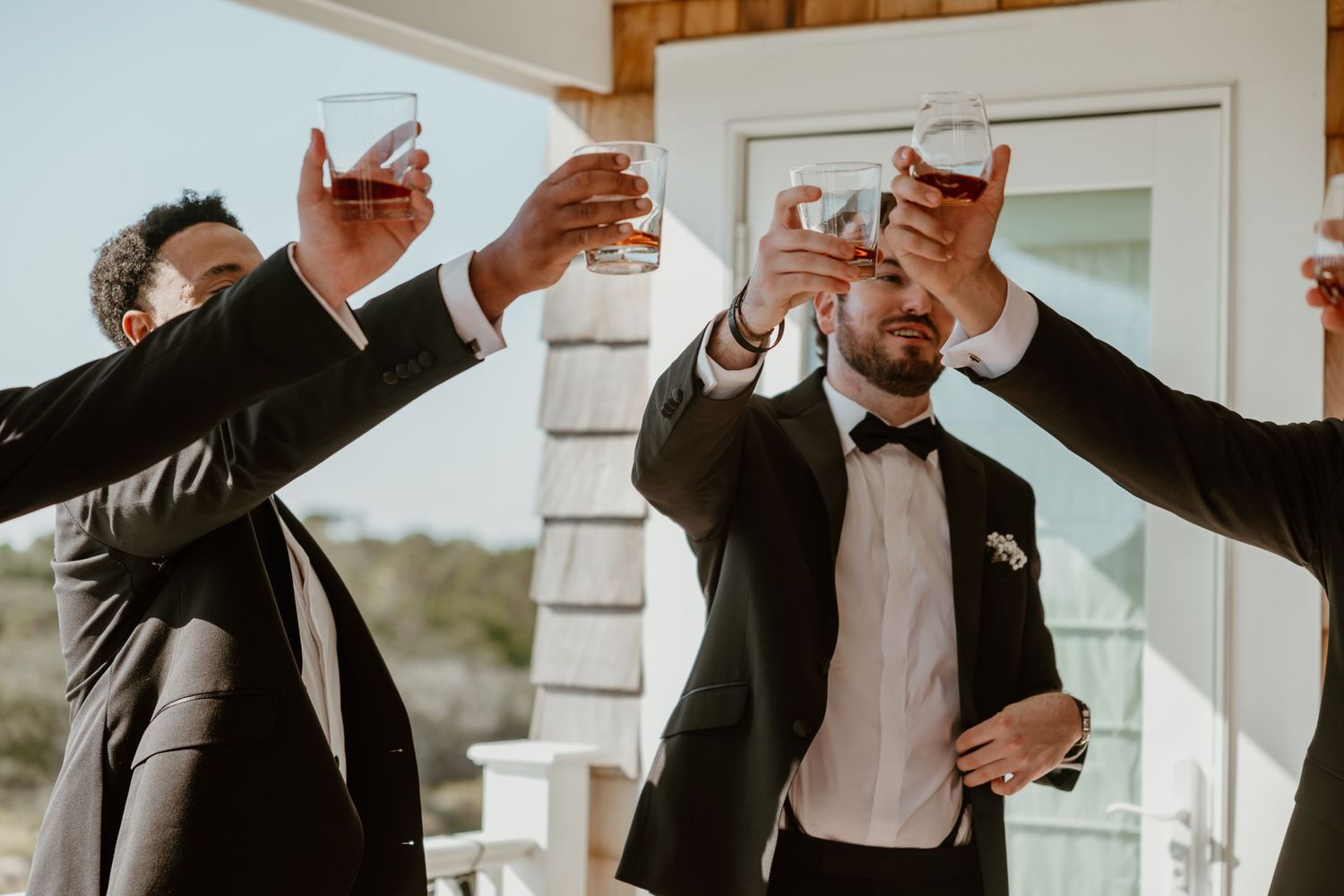 Group toasting with champagne glasses on a sunny porch.