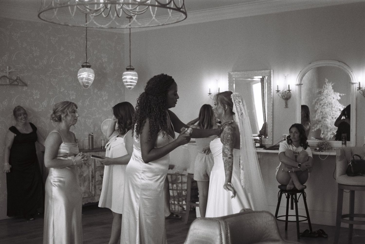 A series of black and white photos showing a wedding celebration with dancing and socializing in an indoor venue.
