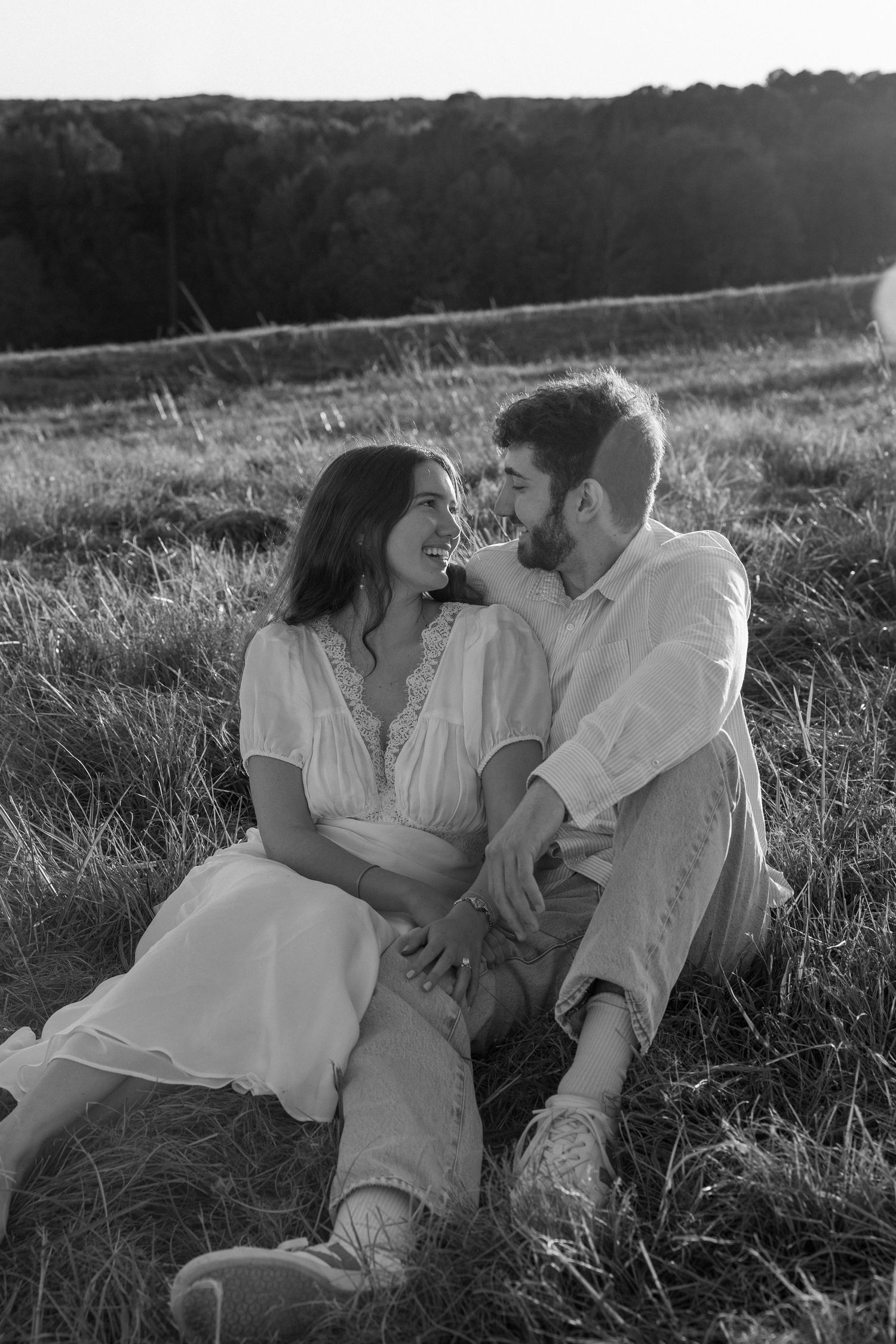 A romantic black and white photo sequence shows a couple lying in a grassy field at sunset.