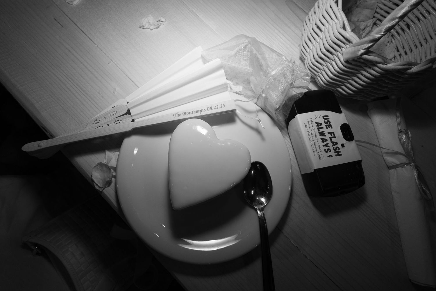 A dark black and white photograph shows an illuminated ceiling light fixture casting dramatic shadows.