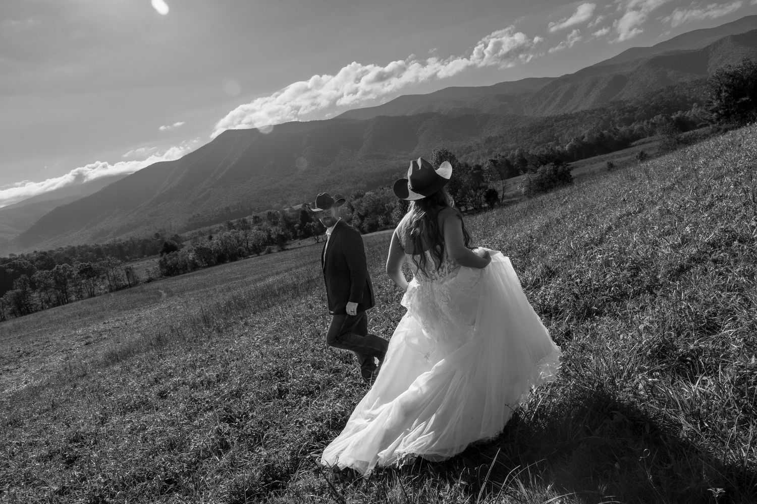 A black and white panoramic series showing a wedding dress flowing in the wind across a mountain landscape.