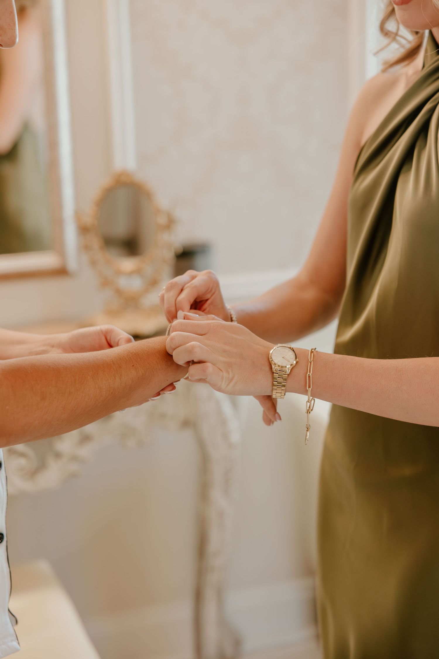 Close-up of hands exchanging jewelry or rings in warm indoor lighting.