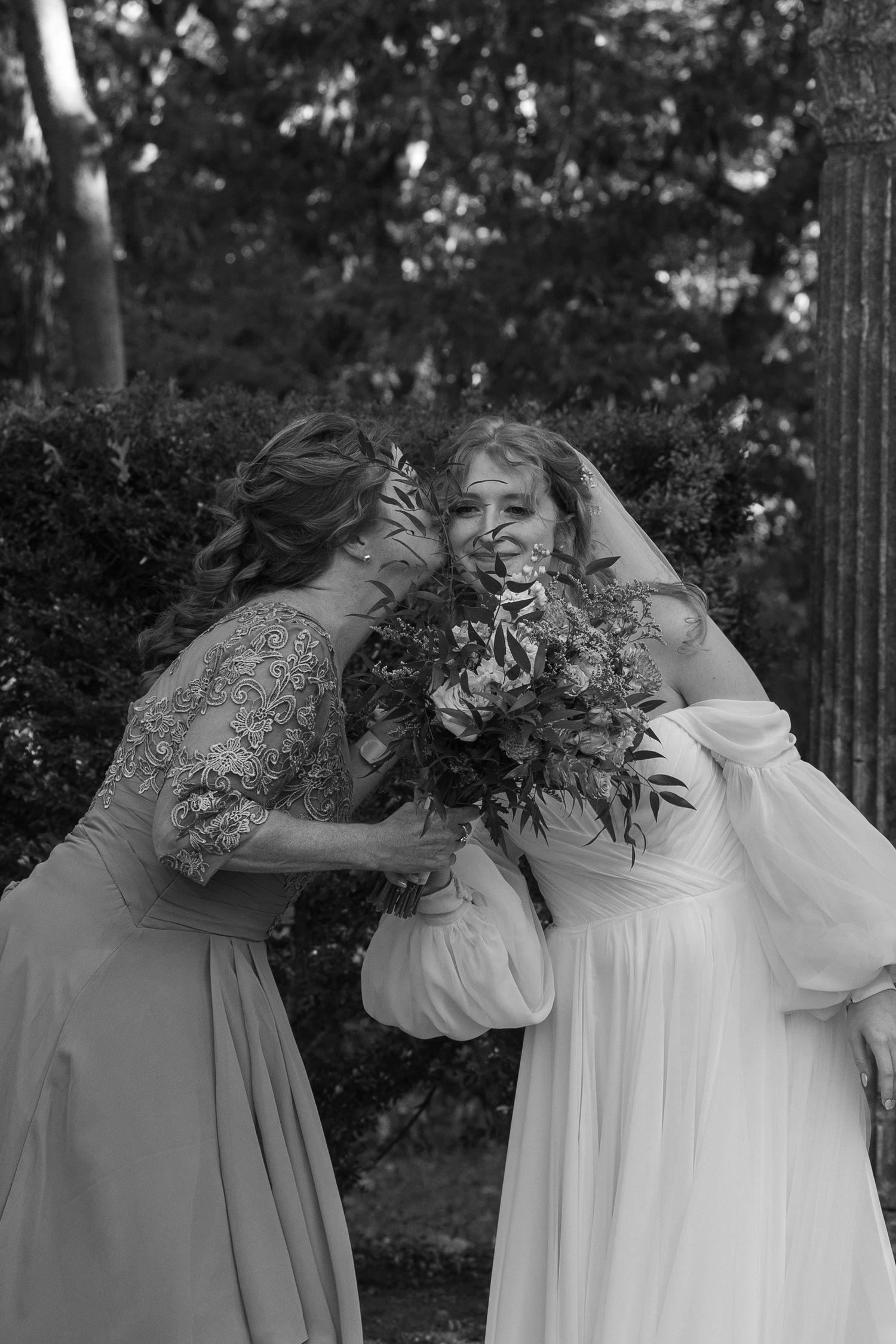 A sequence of black and white photos showing people embracing in an outdoor setting with natural foliage.