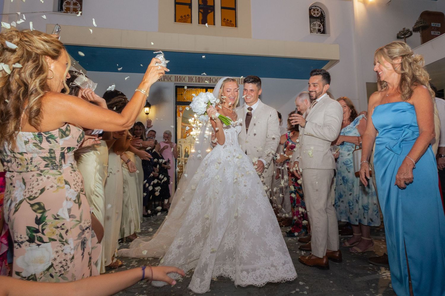 Wedding reception scene with guests in colorful attire celebrating on a dance floor with festive decorations.