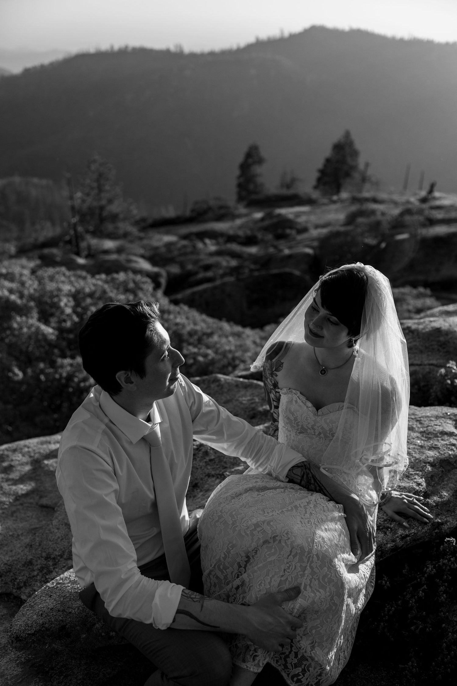 Black and white intimate portrait of couple on rocky mountain terrain.