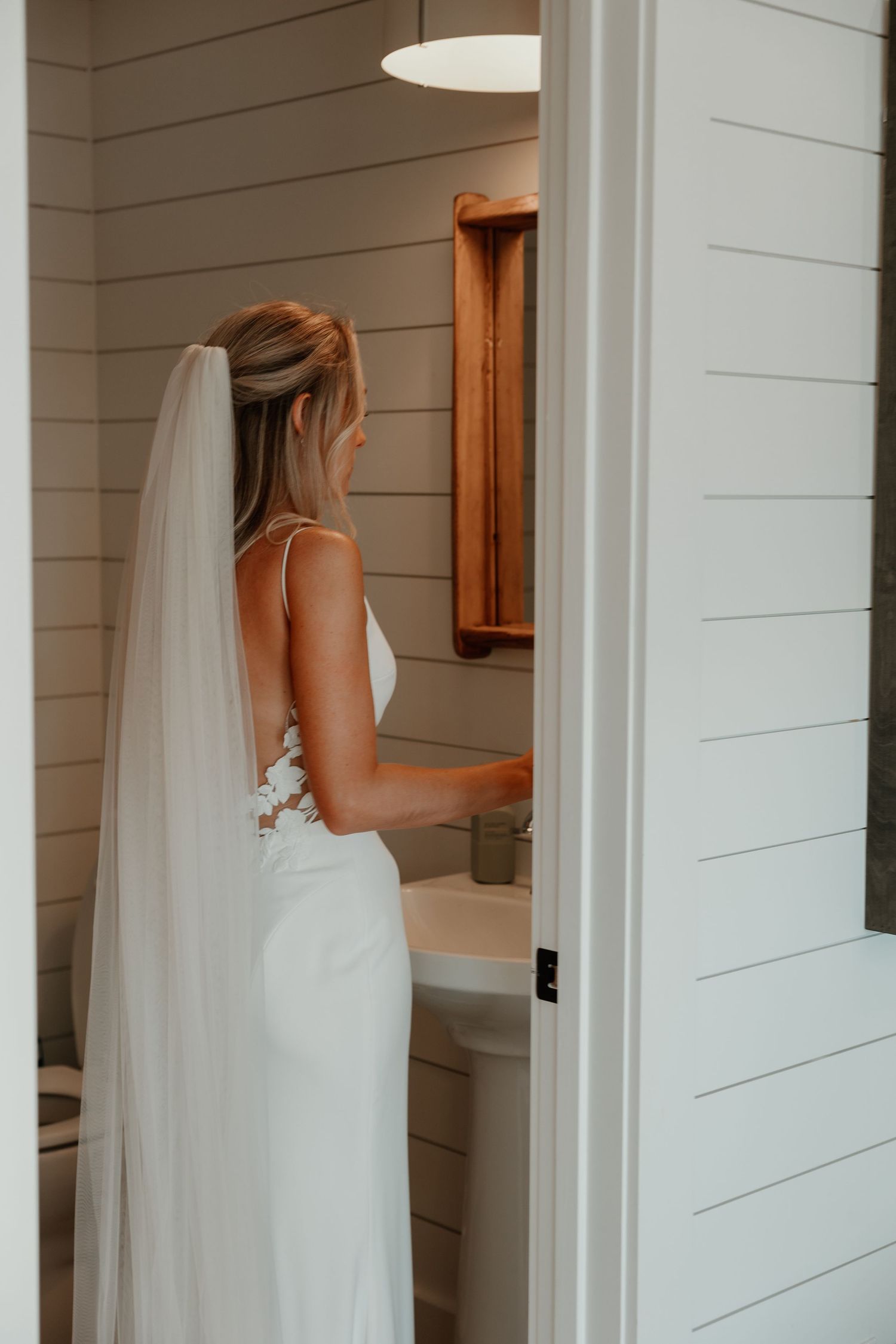 Interior shot of wedding preparations in a white shiplap-walled room.