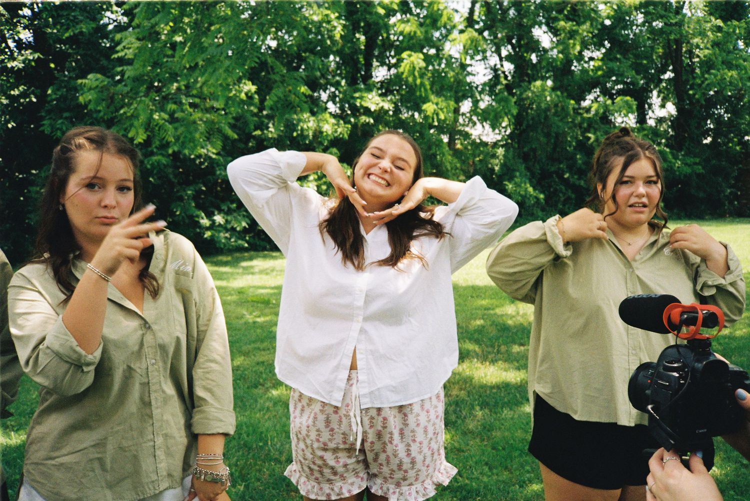 People enjoying a sunny day outdoors in a park with green trees and natural surroundings.