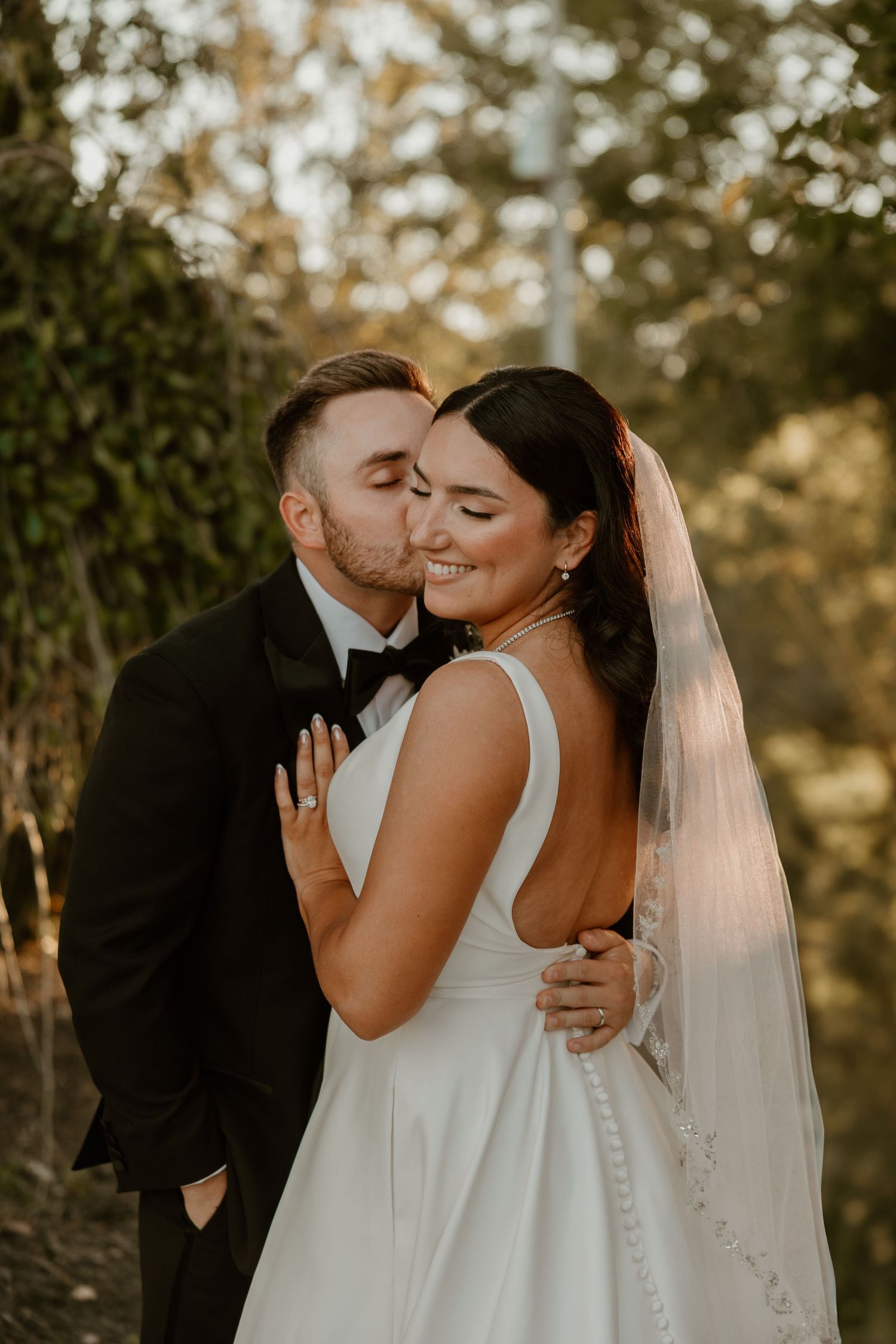 Intimate wedding portrait of a couple sharing a tender moment at sunset.