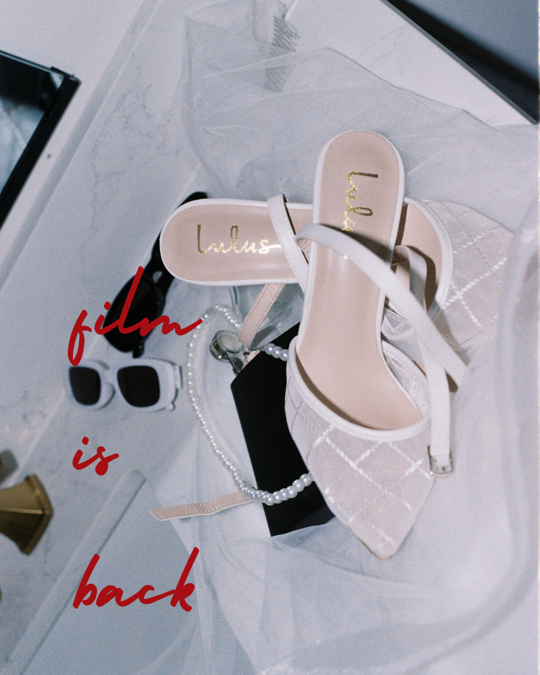 Elegant white bridal shoes with sunglasses and text overlay on white fabric.